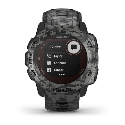 ساعة Garmin Instinct Solar ذات الإصدار المموه (Camo Edition)، مزودة بحزام سيليكون رمادي مموه وشاشة ملونة بالكامل.